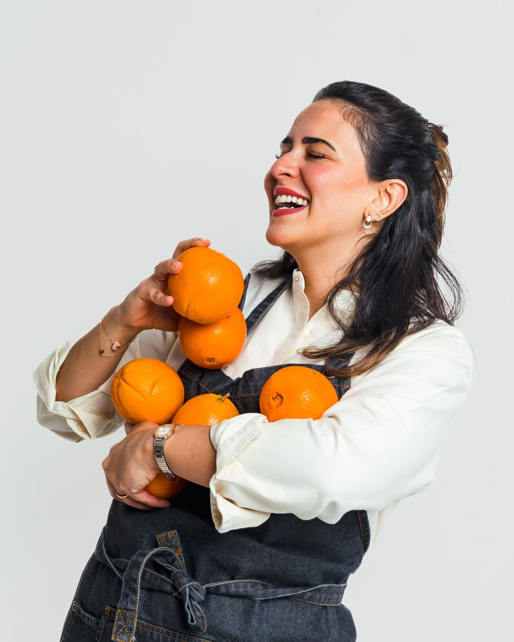 Chef Kholoud laughing while holding oranges